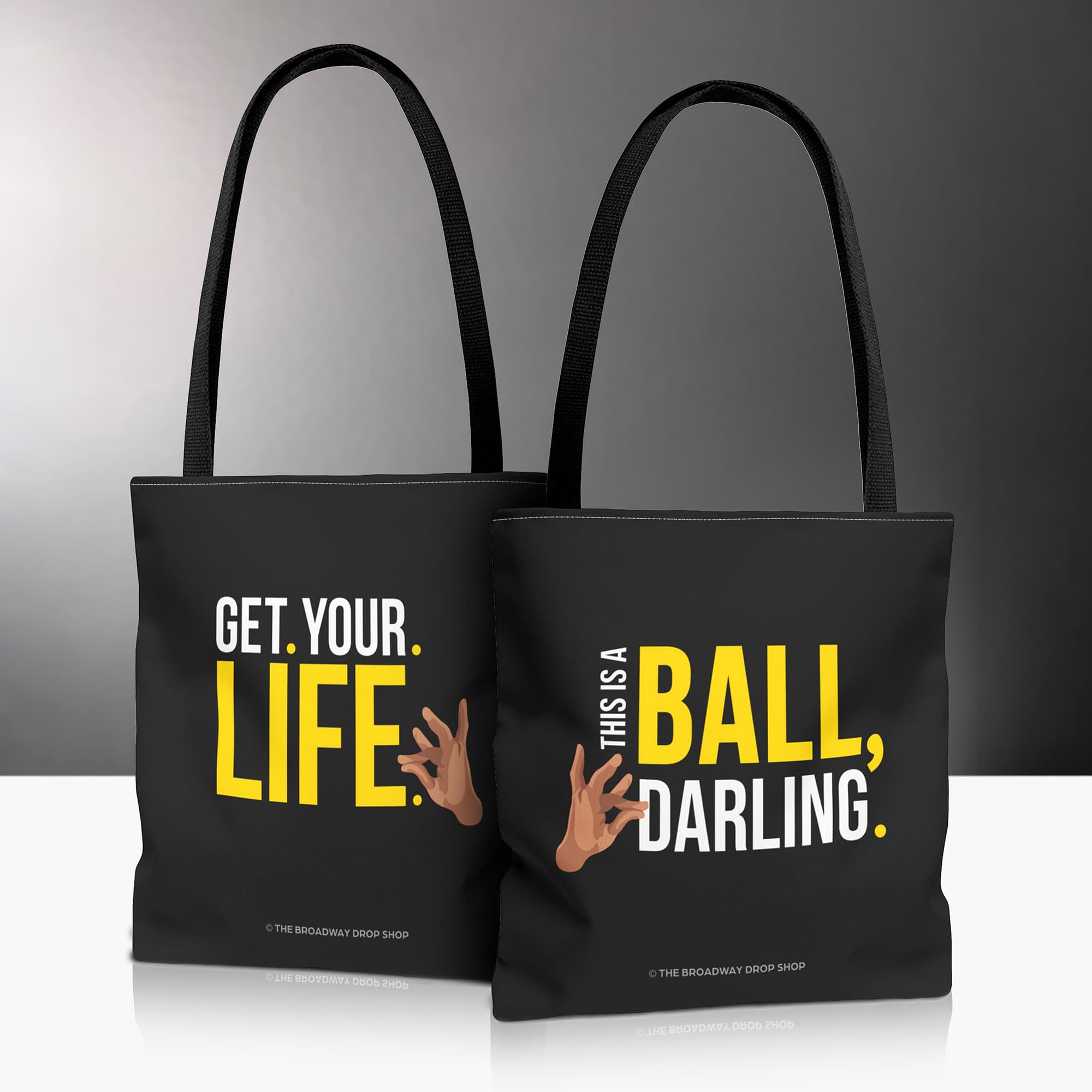 A black tote back bag with "This Is A Ball, Darling" and "Get Your Life" printed on it