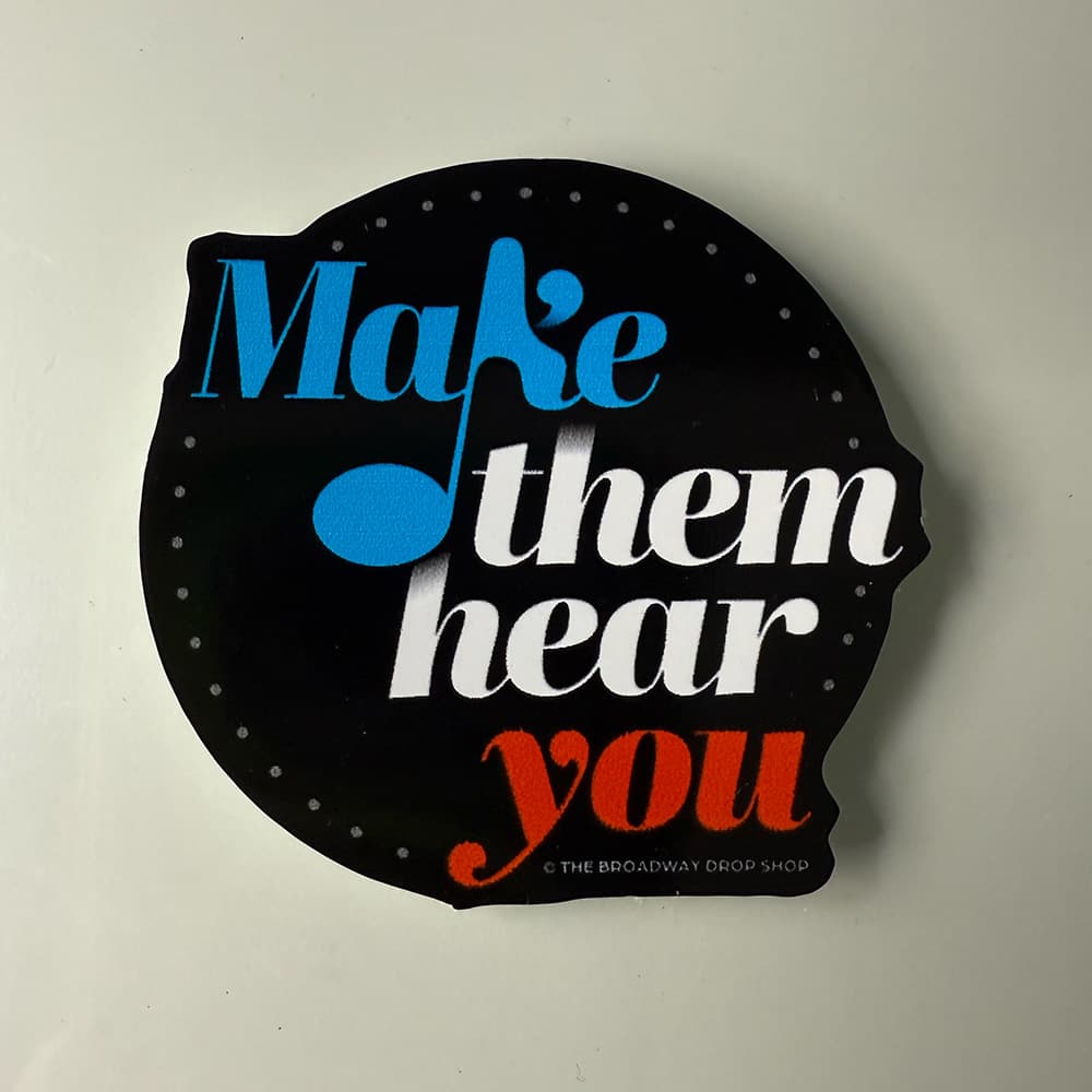 Black die-cut sticker reading "Make them hear you" in blue, white, and red lettering.